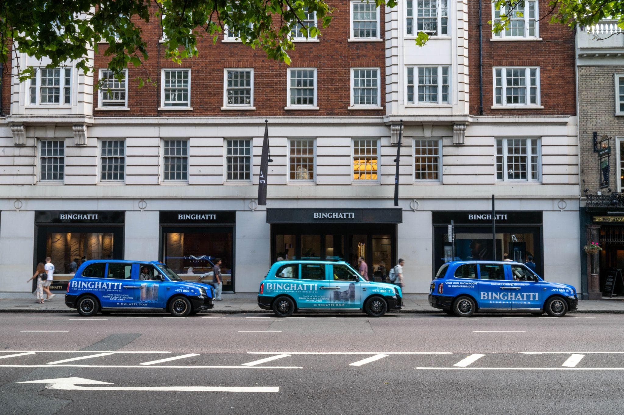 Three Binghatti-branded London taxis parked outside the Binghatti showroom in Knightsbridge